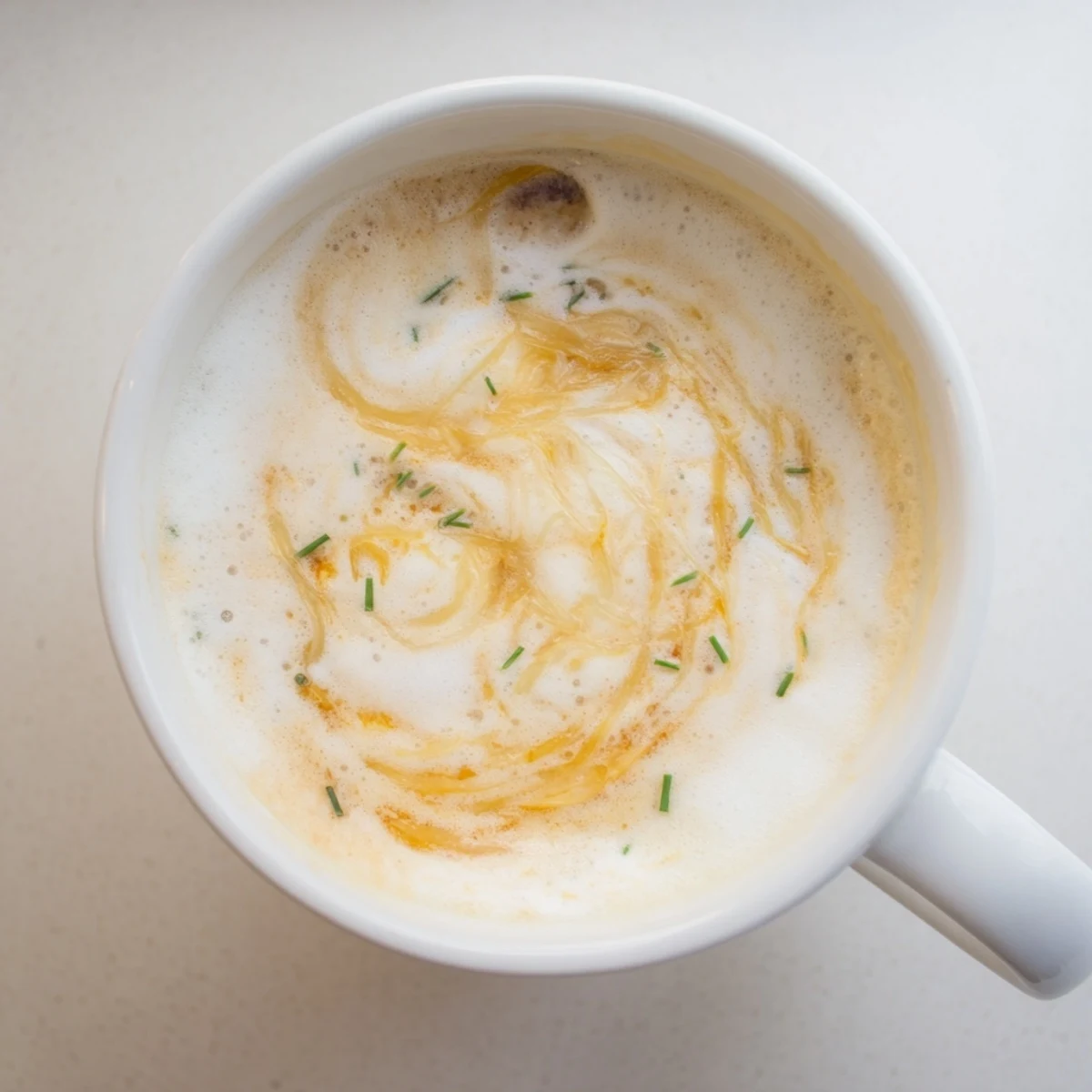 Gourmet onion latte featuring deep caramelized onions, served warm with a frothy finish.