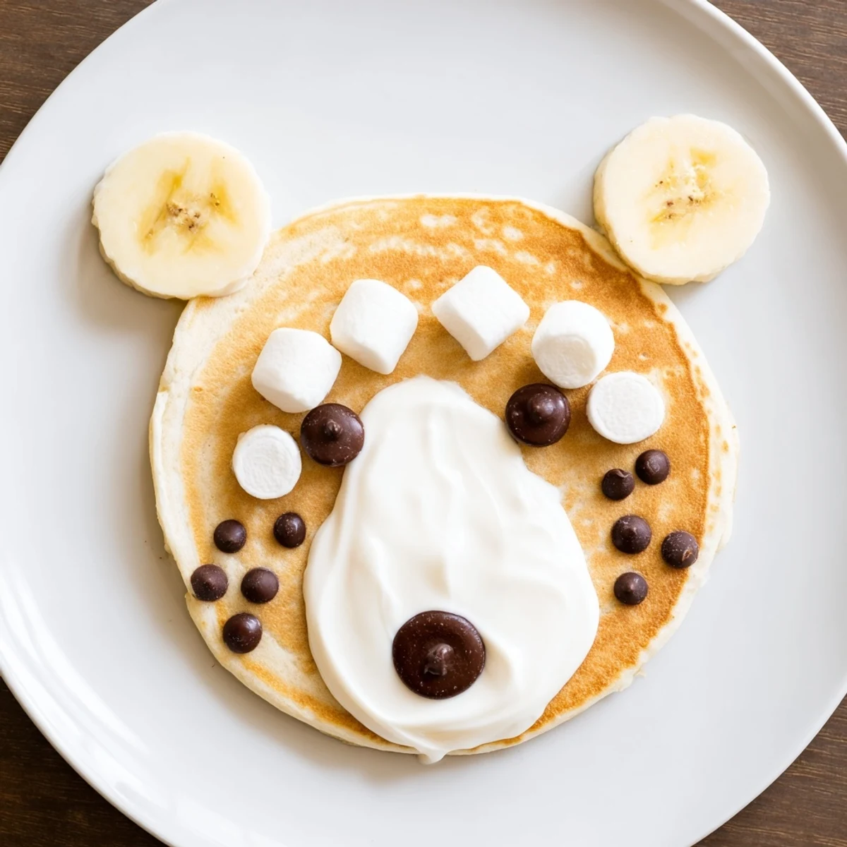 A beautifully arranged Polar Bear Pancake Stack with mini marshmallow ears and chocolate chip eyes, ready for serving!