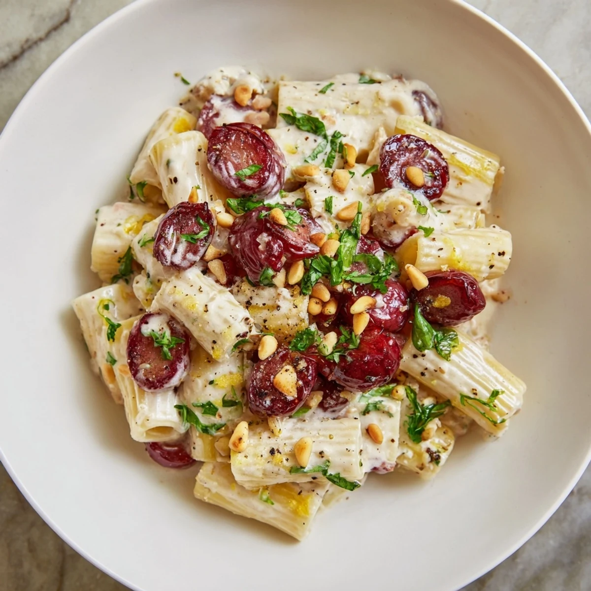 Brightly plated Pasta with Roasted Grapes, showcasing the textures of the ricotta, pasta, and herbs.