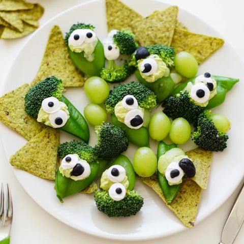 Vibrant Attaque dExtraterrestres Snacks Verts platter: crisp veggies, green dip faces with olive eyes, ready to devour.