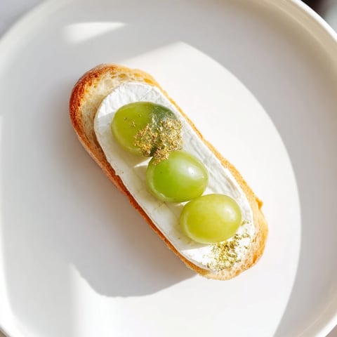 Golden glistening Sparkling Champagne Toast appetizers are ready, featuring prosecco-soaked grapes and creamy cheese.