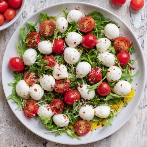 Elegant Pearly Strand salad: mozzarella pearls artfully draped over fresh tomatoes and basil.