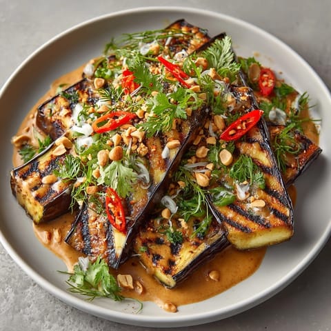 Vibrant Thai Peanut Grilled Eggplant recipe, garnished with cilantro and peanuts.