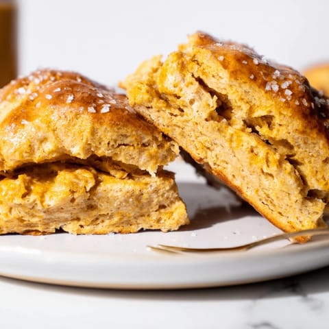 Golden brown Flaky Pumpkin Pancake Pretzel Scones topped with coarse salt and served warm.  