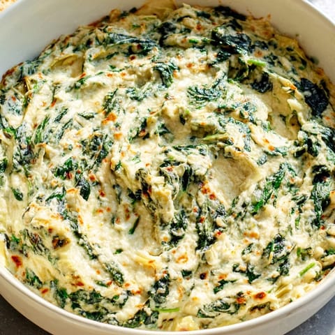 Close up shot of golden brown Cheesy Spinach Artichoke Dip, perfect for an easy appetizer to share.