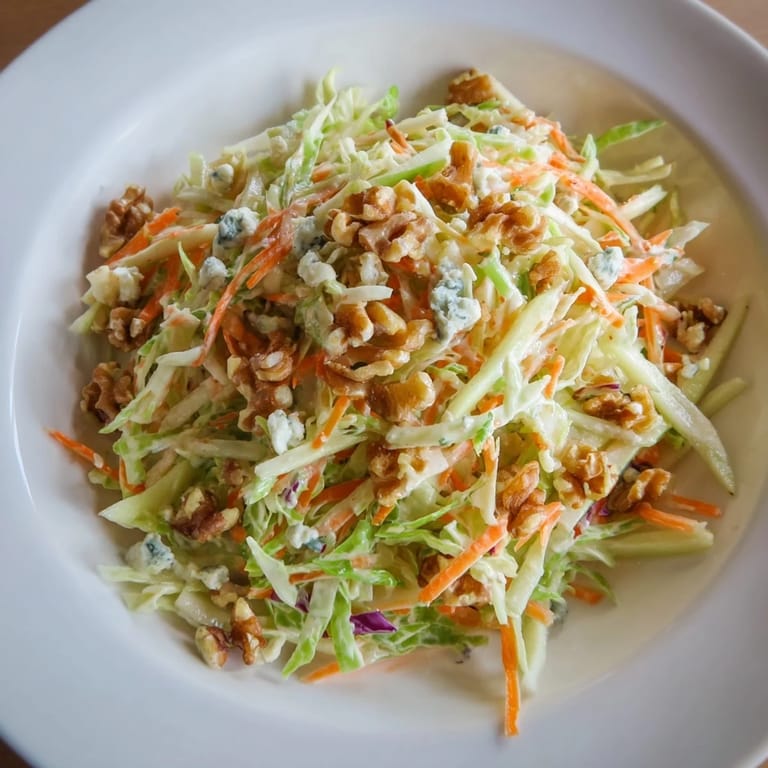 This photo presents a delicious, flavorful bowl of Crunchy Apple & Walnut Slaw with a creamy, rich dressing.