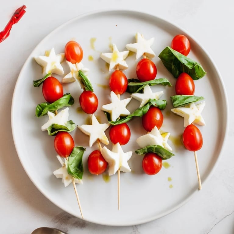 Star-shaped Caprese skewers drizzled with balsamic glaze, a colorful and easy appetizer bursting with Italian flavors.