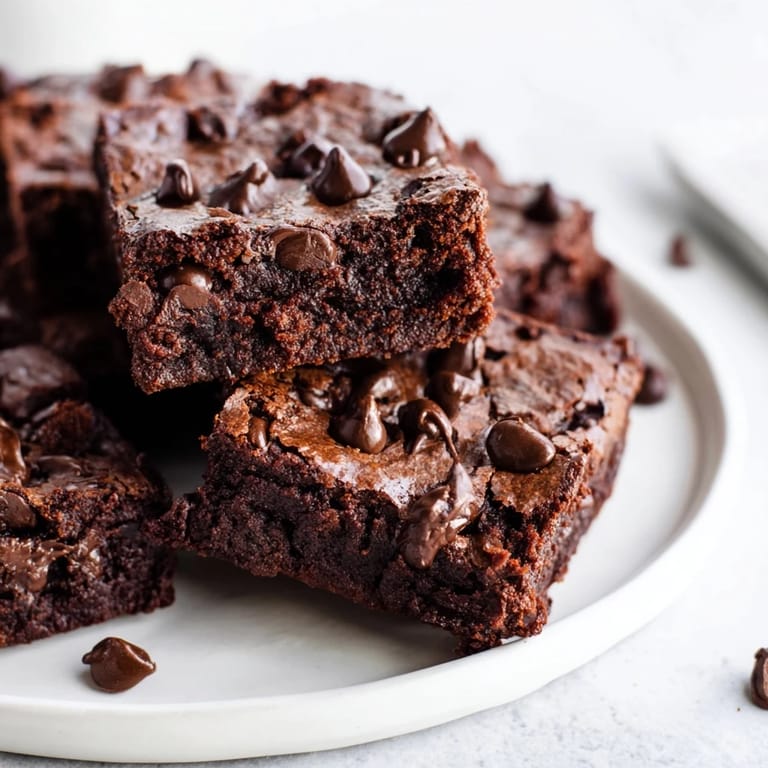 Warm, dark photograph of Greek yogurt brownies, a healthy dessert option perfect for chocolate lovers, ready to enjoy.
